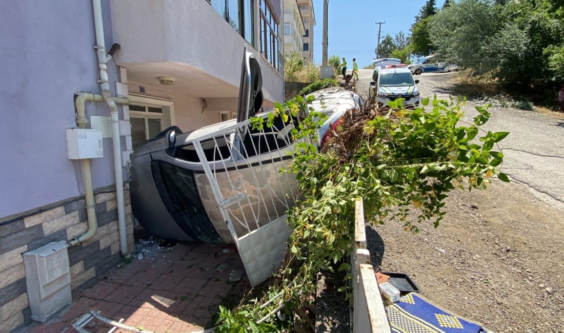 Karabük'te şoförünün denetiminden çıkan araba, apartman bahçesine girip yan yattı.