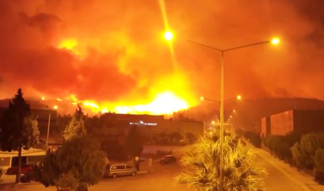 İzmir'in Buca ilçesindeki orman yangını havadan görüntülenirken, alevlerin yerleşim yerlerini