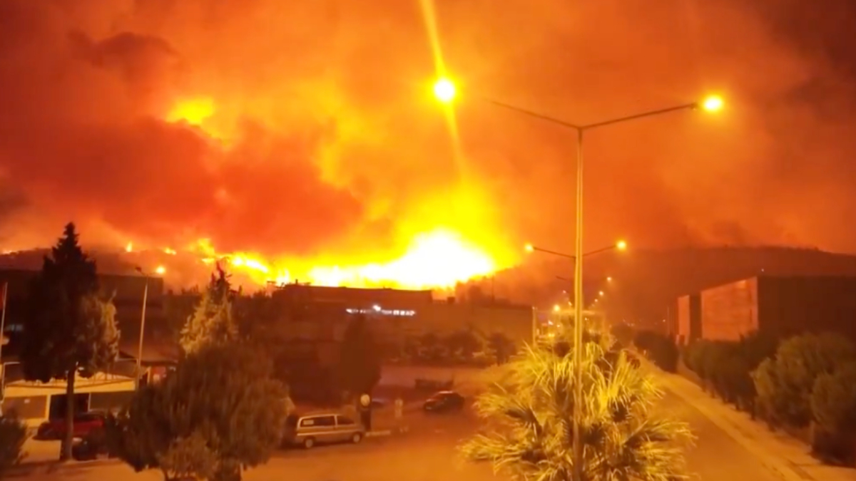 İzmir'in Buca ilçesindeki orman yangını havadan görüntülenirken, alevlerin yerleşim yerlerini