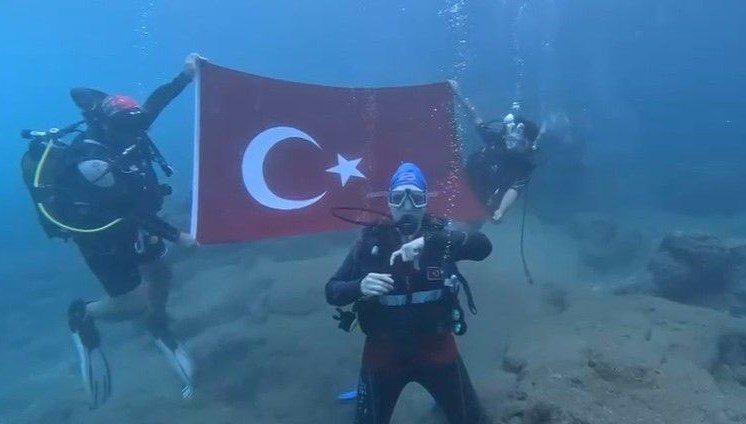 Antalya'da Cumhuriyet'in 102. yılı dolayısıyla dalgıçlar, denizin altında Türk bayrağı açıp işaret