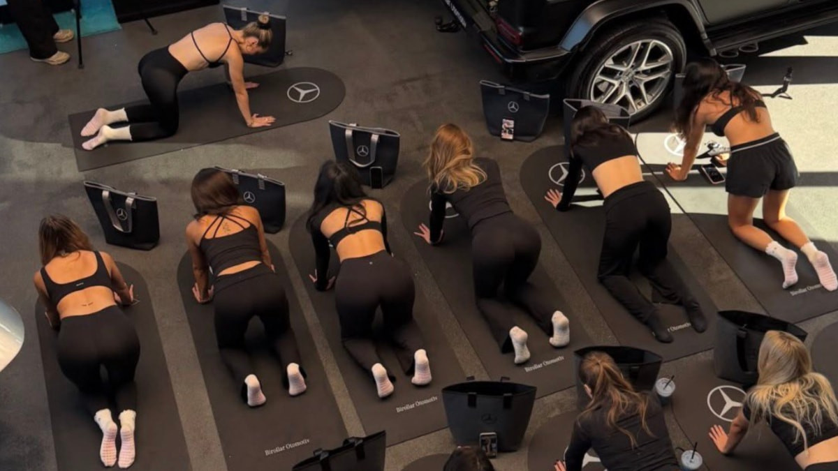 Bir otomobil bayisinde düzenlenen sabah yogası etkinliğinde bir araya gelen